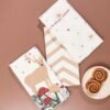45x70 cm cotton tea towel with reindeer print folded beside holiday decor (2) 45x70 cm cotton tea towel with reindeer print folded beside holiday decor