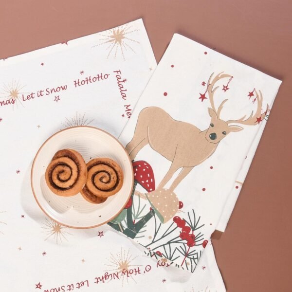 45x70 cm cotton tea towel with reindeer print folded beside holiday decor (3) 45x70 cm cotton tea towel with reindeer print folded beside holiday decor