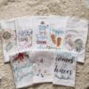 Thick custom cotton tea towel with embroidered logo on wooden table (5) Thick custom cotton tea towel with embroidered logo on wooden table
