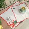 Scalloped edge embroidered cotton placemat on dining table