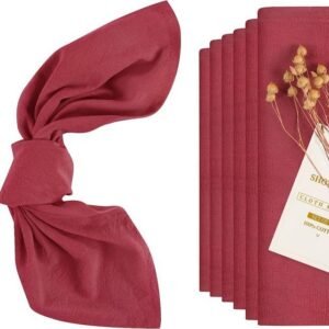 Red washed cotton napkin neatly folded on restaurant table setting